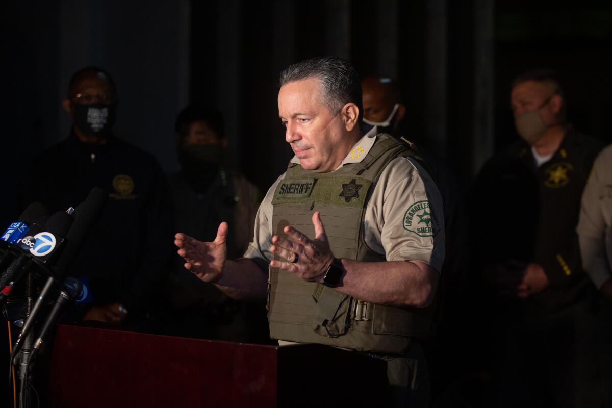 L.A. County Sheriff Alex Villanueva, wearing a bulletproof vest, speaks at a late-night news conference