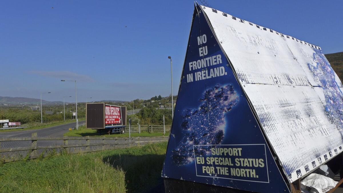 A sign in a cemetery parking lot near Carrickcarnan, Ireland, sits right next to the Jonesborough Parish church in Northern Ireland. "Brexit" negotiators want to ensure that no hard border is created between the EU's Ireland and Britain's Northern Ireland.