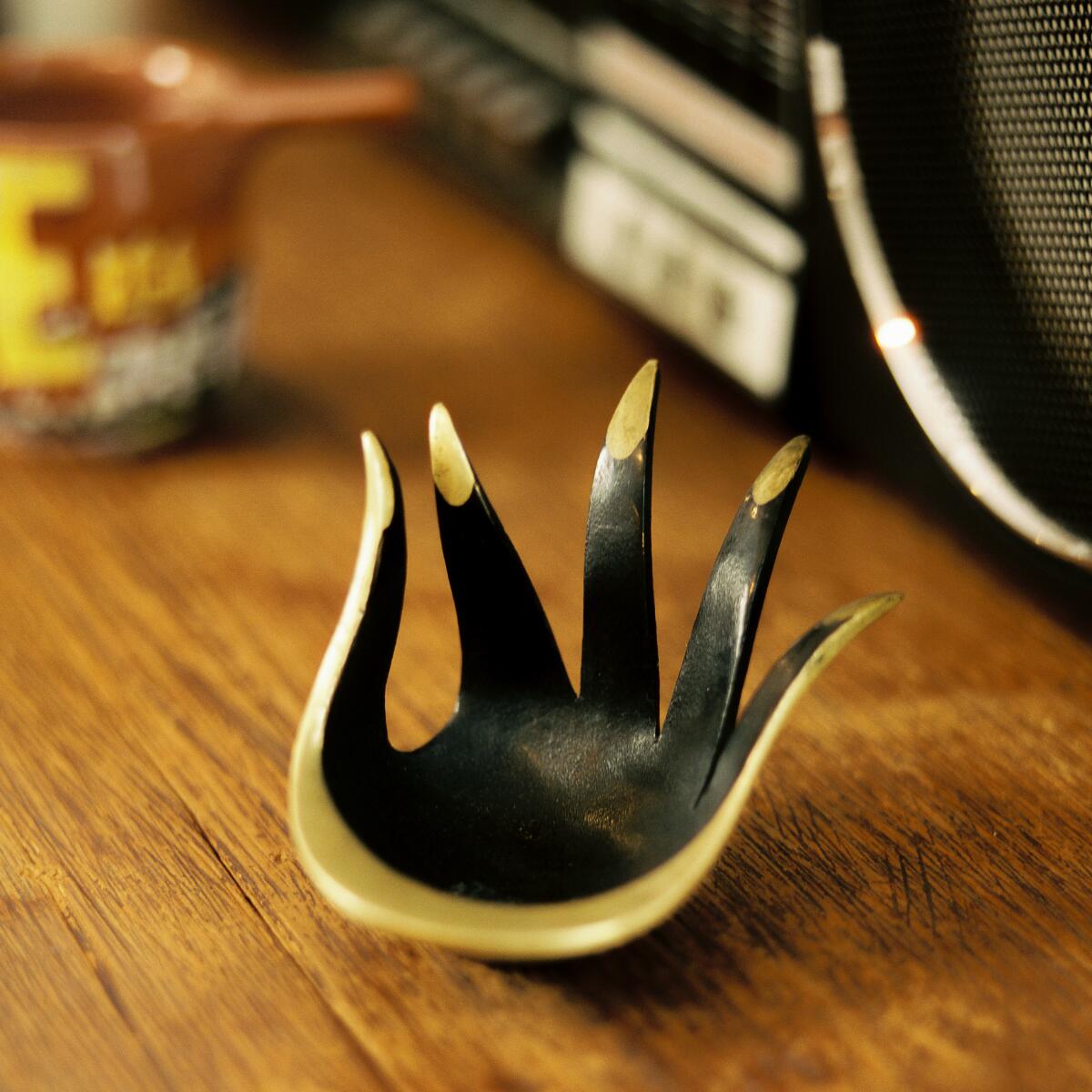 A hand-shaped ashtray with thumb and index finger close together.