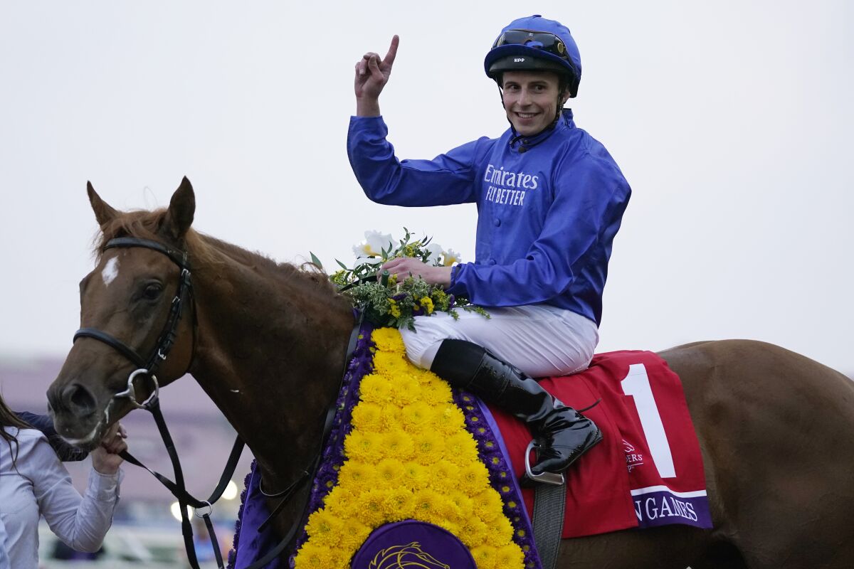 William Buick celebrates atop Modern Games after winning the Breeders' Cup Juvenile Turf horse race at the Del Mar racetrack in Del Mar, Calif., Friday, Nov. 5, 2021. (AP Photo/Jae C. Hong)