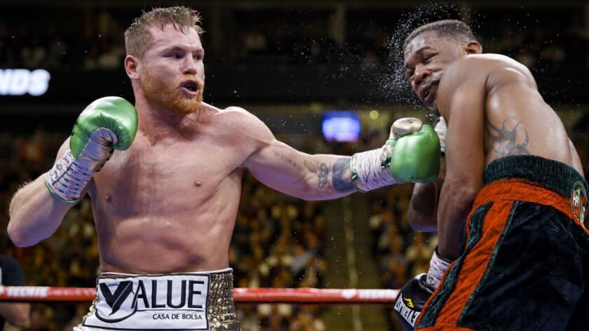 Canelo Alvarez, left, hits Daniel Jacobs during a middleweight title match May 4 in Las Vegas.