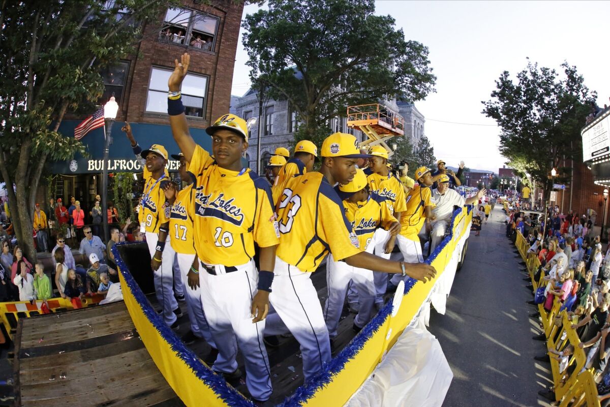 Members of the Jackie Robinson West team from Chicago ride in the Little League Grand Slam Parade as it makes its way through downtown Williamsport, Pa.