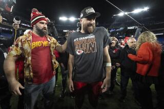 Kansas City Chiefs tight end Travis Kelce, center, talks to his brother Jason Kelce following the AFC Championship NFL football game between the Baltimore Ravens and the Kansas City Chiefs, Sunday, Jan. 28, 2024, in Baltimore. The Chiefs won 17-10. (AP Photo/Julio Cortez)