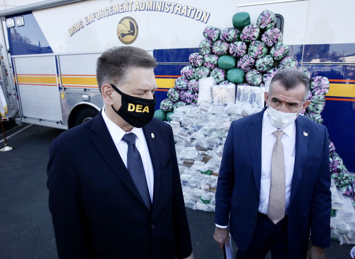 DEA's Timothy J. Shea and Bill Bodner stand next to a huge haul of meth, cocaine, heroin at the DEA warehouse.