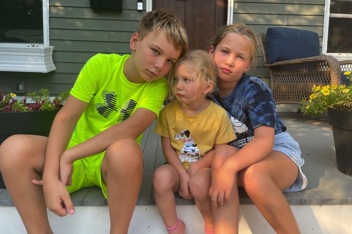 Forced to quarantine instead of attending the first days of school, Rylan, 10, Maddie, 3 and Amelia, 8, pose in Maplewood, N.J., Sept. 13, 2021, for an anti-back to school picture instead. Their mom, Associated Press editor Noreen Gillespie, decided to take the photo after her three kids were exposed to COVID and had to quarantine as their friends were going back to the classroom. (AP Photo/Noreen Gillespie)