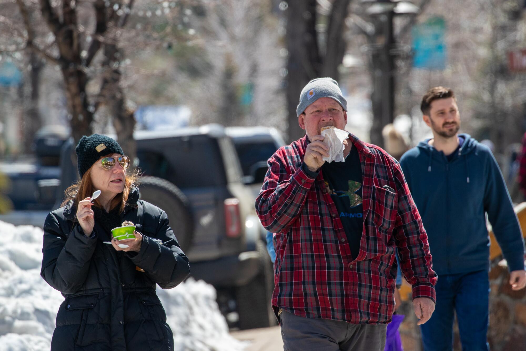 A woman and man eat ice cream while walking through the downtown district of Big Bear.