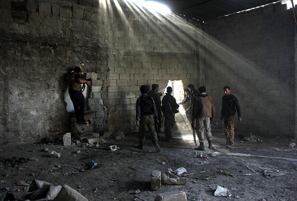 Rebel fighters inside a building during clashes with pro-government forces in the Sheikh al-Said neighborhood of Syria's northern city of Aleppo.