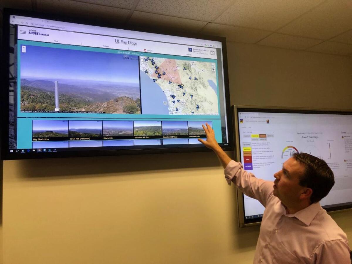Brian D’Agostino, the director of fire science and climate adaptation at San Diego Gas & Electric, gestures at one of monitors at SDG&E's Weather Center in Kearny Mesa.