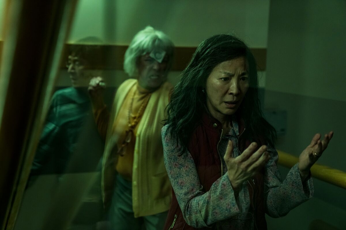 Michelle Yeoh looks at her hands as Jamie Lee Curtis raises a fist in "Everything Everywhere All At Once."