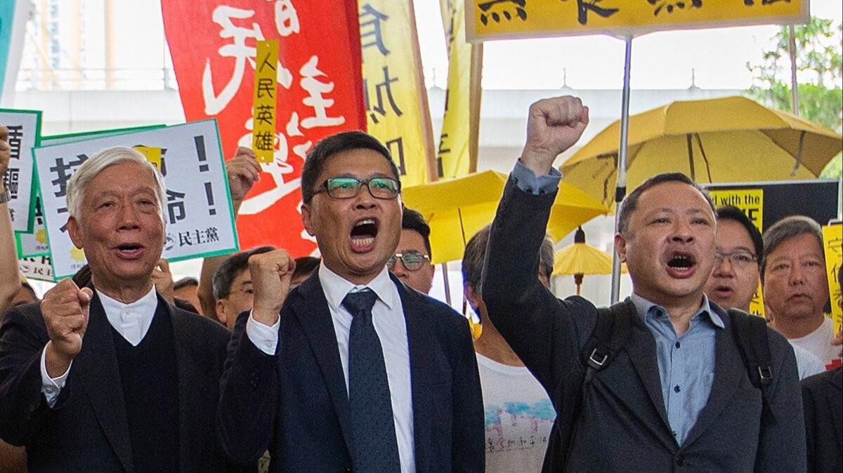 Occupy Central activists, from left, the Rev. Chu Yiu-ming, Chan Kin-man and Benny Tai prepare to enter court at West Kowloon Magistrates Court, Hong Kong, on Tuesday.