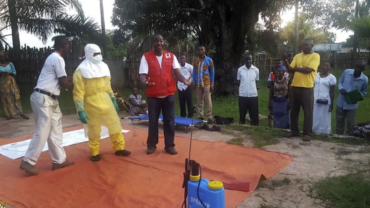 Members of a Red Cross team don protective clothing in Mbandaka, Congo, before heading out to look for Ebola cases.