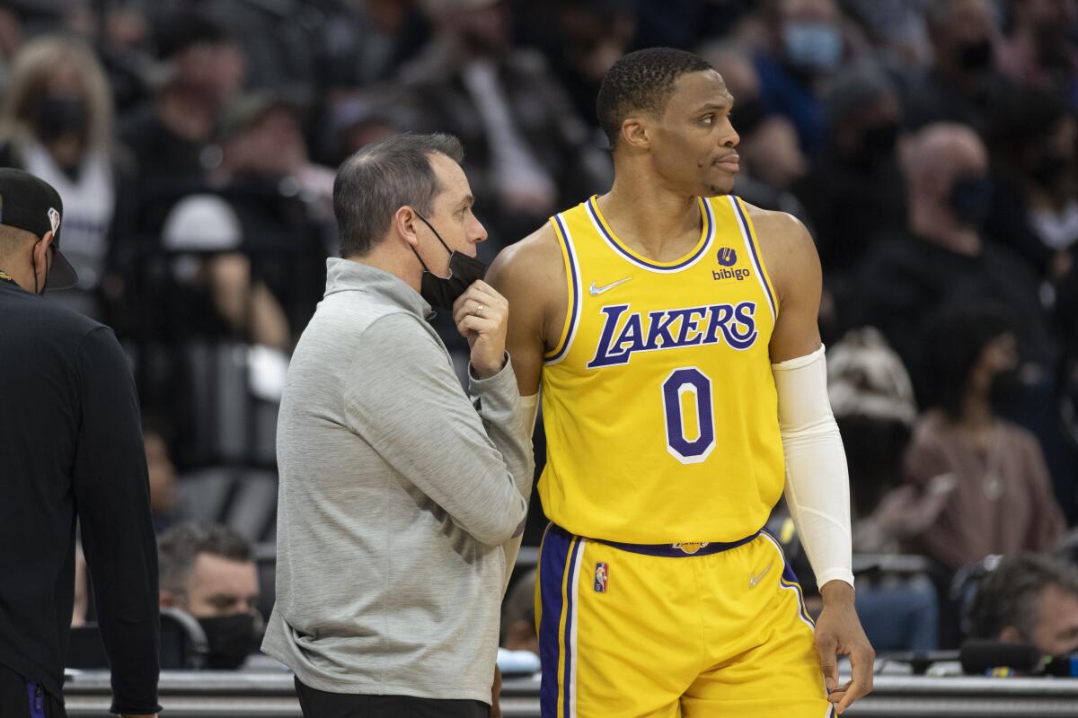 Lakers guard Russell Westbrook listens to head coach Frank Vogel along the sideline.