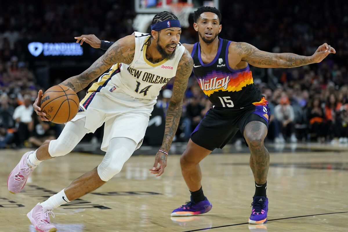 New Orleans Pelicans forward Brandon Ingram (14) dries as Phoenix Suns guard Cameron Payne (15) defends during the second half of Game 2 of an NBA basketball first-round playoff series, Tuesday, April 19, 2022, in Phoenix. (AP Photo/Matt York)
