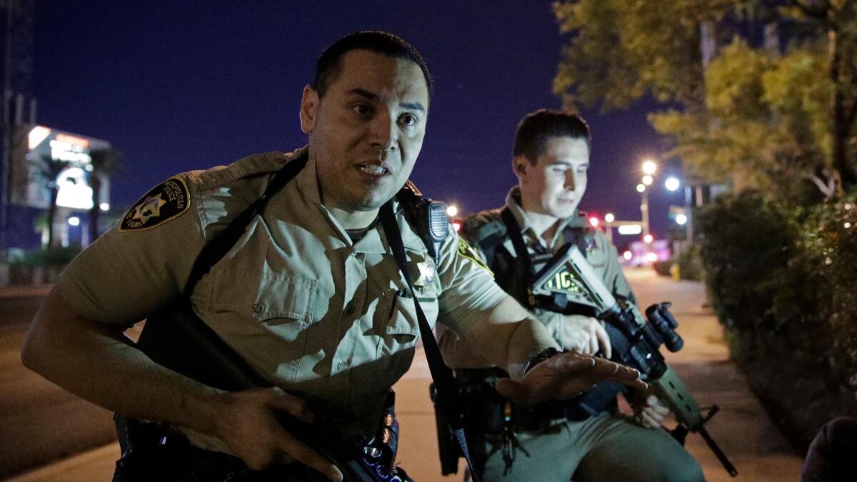 Las Vegas police officers order people to take cover near the scene of the deadly Las Vegas shooting on Oct. 1, 2017.