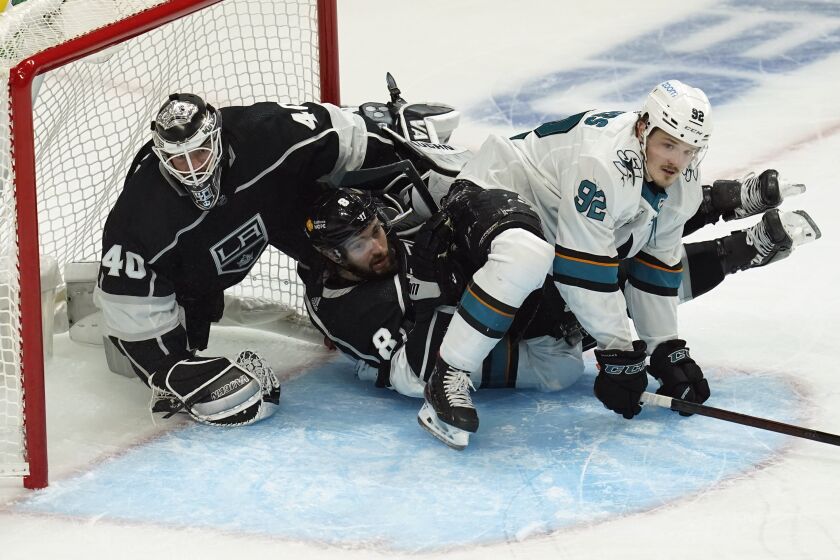 San Jose Sharks left wing Rudolfs Balcers (92) crashes in to Los Angeles Kings goaltender Calvin Petersen (40) and defenseman Drew Doughty (8) during the second period of an NHL hockey game Tuesday, Feb. 9, 2021, in Los Angeles. (AP Photo/Ashley Landis)
