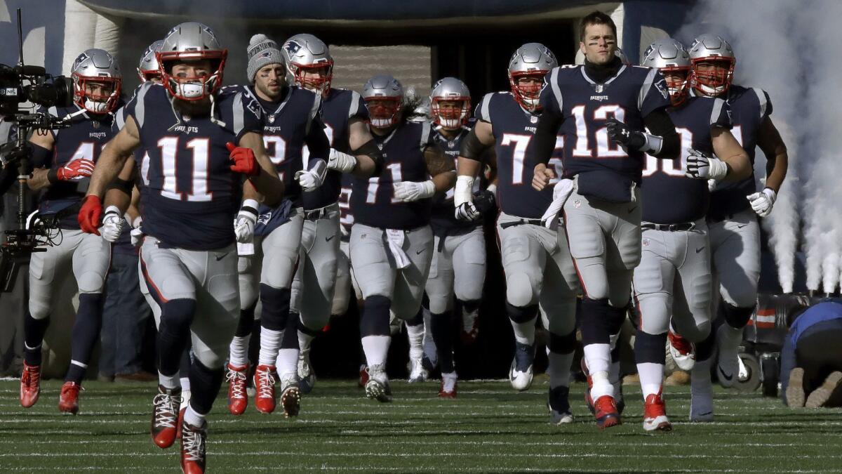 New England Patriots wide receiver Julian Edelman (11) and quarterback Tom Brady (12) lead their team onto the field before an NFL divisional playoff game against the Chargers in Foxborough, Mass. on Sunday.