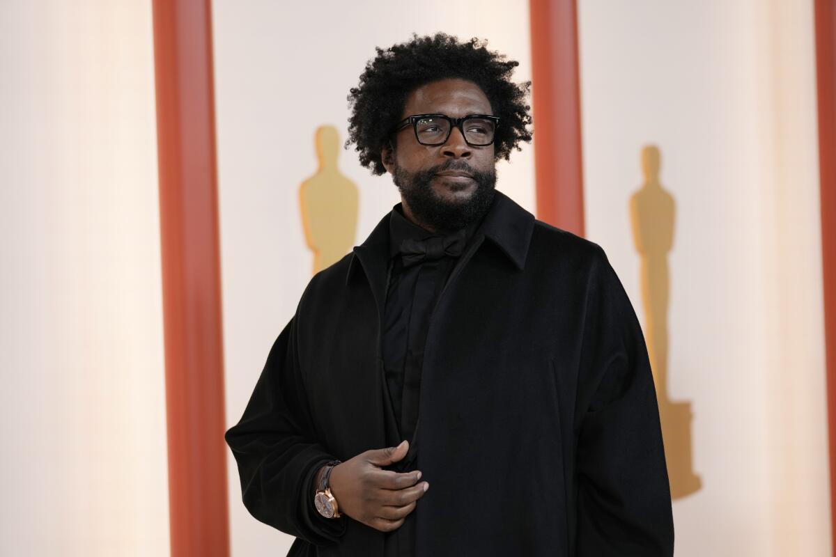 Questlove luce sobrio en su atuendo de color negro.