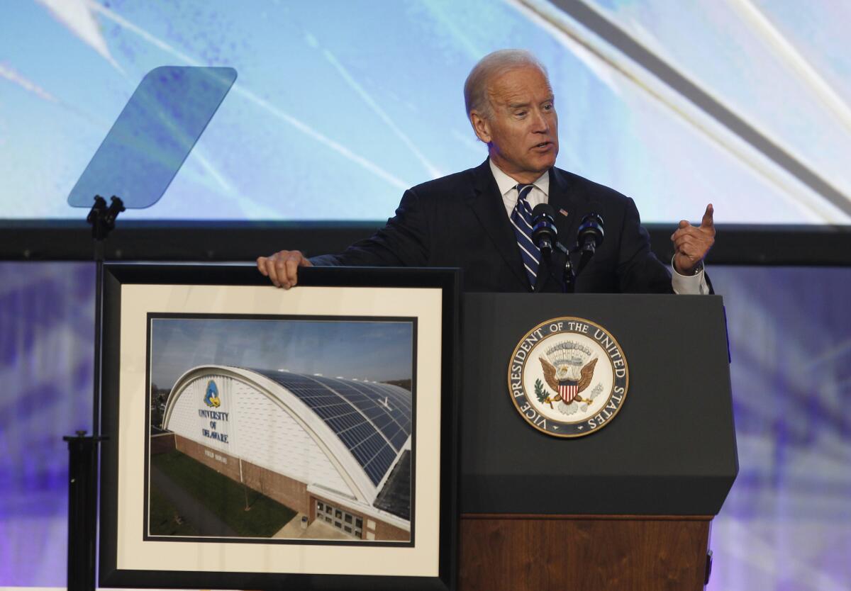 Vice President Biden displays a photo of solar panels mounted on the field house at the University of Delaware as he speaks at the Solar Power International conference in Anaheim.