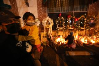 MONTEREY PARK, CA - JANUARY 26, 2023 - - Daniel Lopez, 40, and his daughter Amaya, 4, from Alhambra, pay their respects at the memorial for 11 people who died in a mass shooting during Lunar New Year celebrations outside the Star Ballroom Dance Studio in Monterey Park on January 26, 2023. (Genaro Molina / Los Angeles Times)
