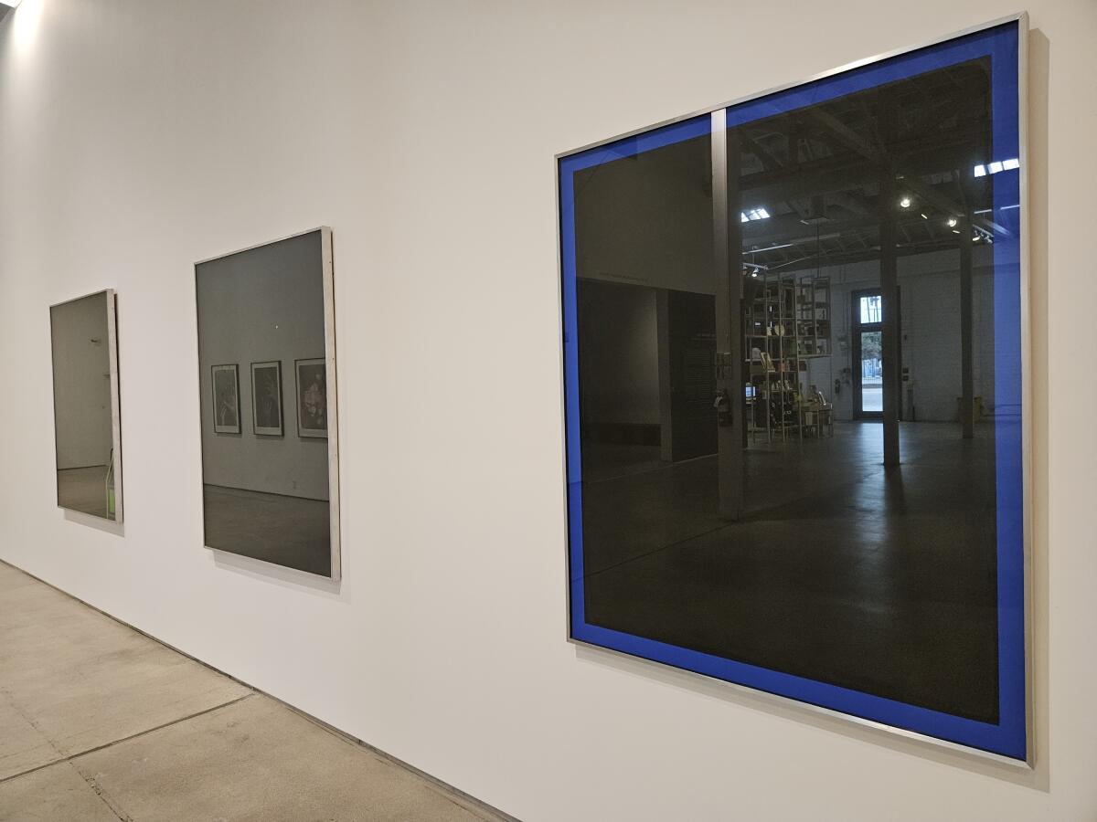 Black glass paintings reflect their museum surroundings. 