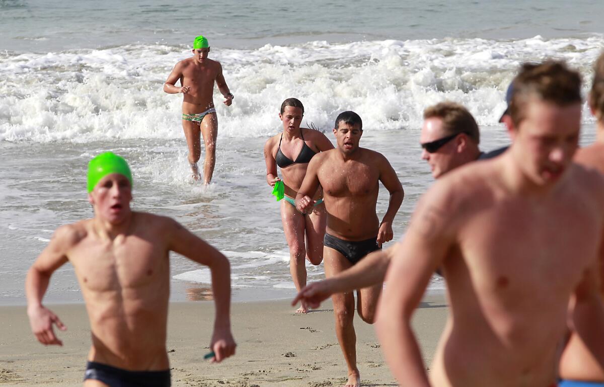 People competing to become Laguna Beach ocean lifeguards try out in 2014. This year's tryouts for seasonal positions are Saturday and March 11.