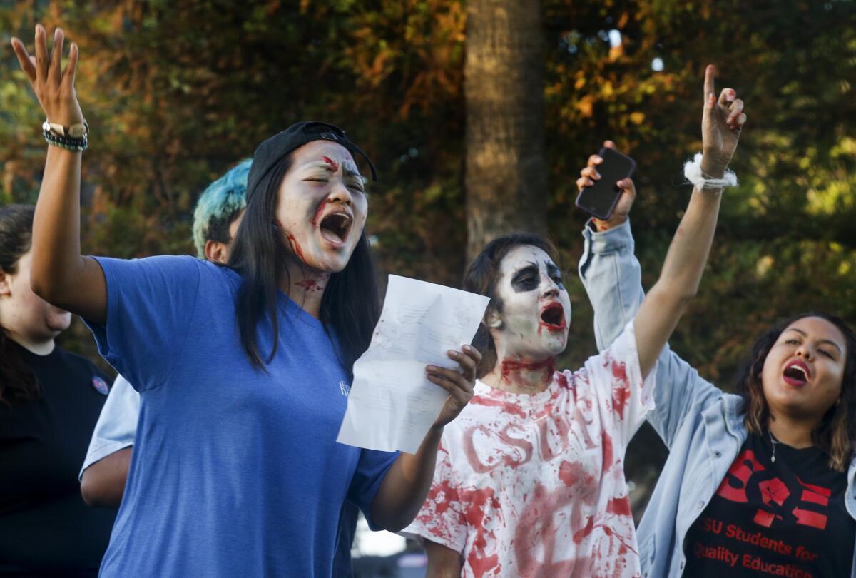 Cal State Fullerton student Ginny Dolores, left, leads students outside a trustees meeting this week in Long Beach protesting a possible tuition hike and calling on the university to protect students who came to the U.S. illegally.