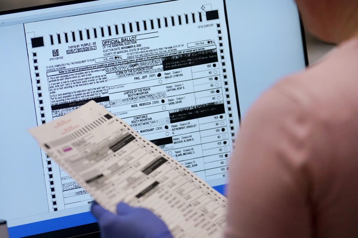 An election worker verifies a ballot on a screen.