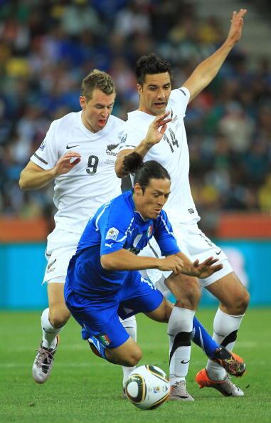 Mauro Camoranesi of Italy is brought down by Shane Smeltz and Andy Barron of New Zealand during the 2010 FIFA World Cup South Africa Group F match between Italy and New Zealand at the Mbombela Stadium on June 20, 2010 in Nelspruit, South Africa.
