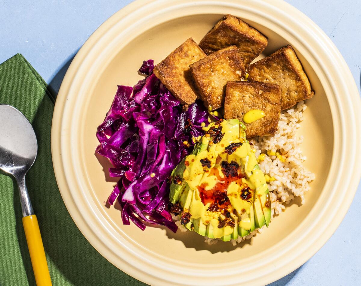 A Tofu bowl with lemon-lime cabbage, avocado and turmeric tahini 