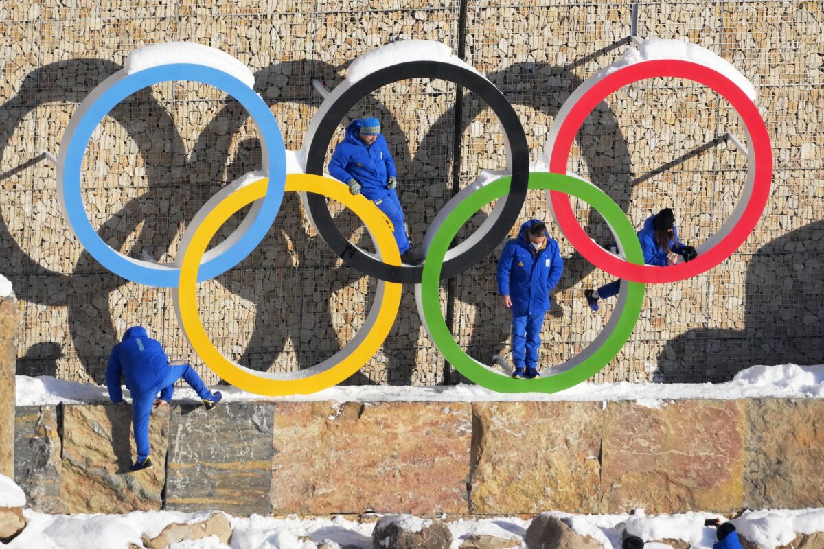 Ukraine team members climb on the Olympic Rings to pose for photo in the Olympic Village at the 2022 Winter Olympics, Monday, Feb. 14, 2022, in the Yanqing district of Beijing. Backers of Sapporo, Japan, to hold the 2030 Winter Olympics have gotten together to promote their bid. The Japanese city is competing with Salt Lake City, Vancouver, and a Spanish group that wants to return the Olympics to Barcelona. (AP Photo/Dmitri Lovetsky)
