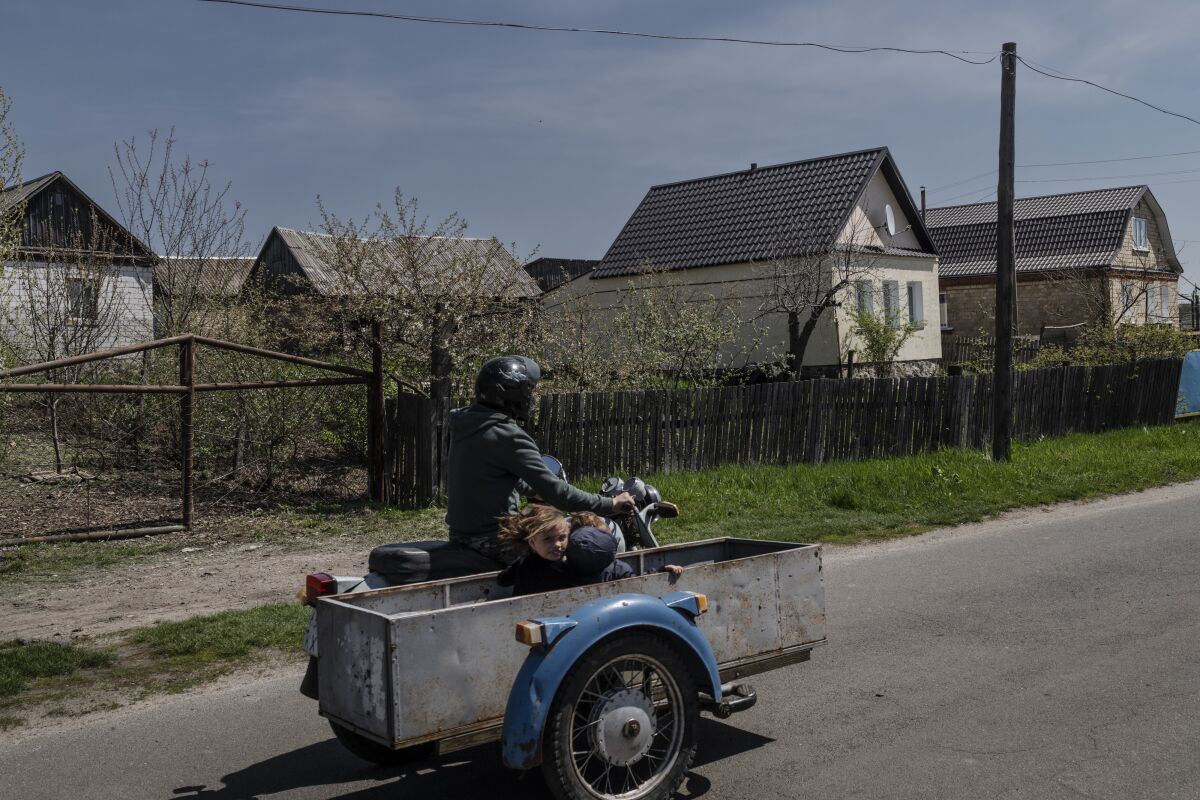 A street scene includes a motorcycle with hand-built sidecar.