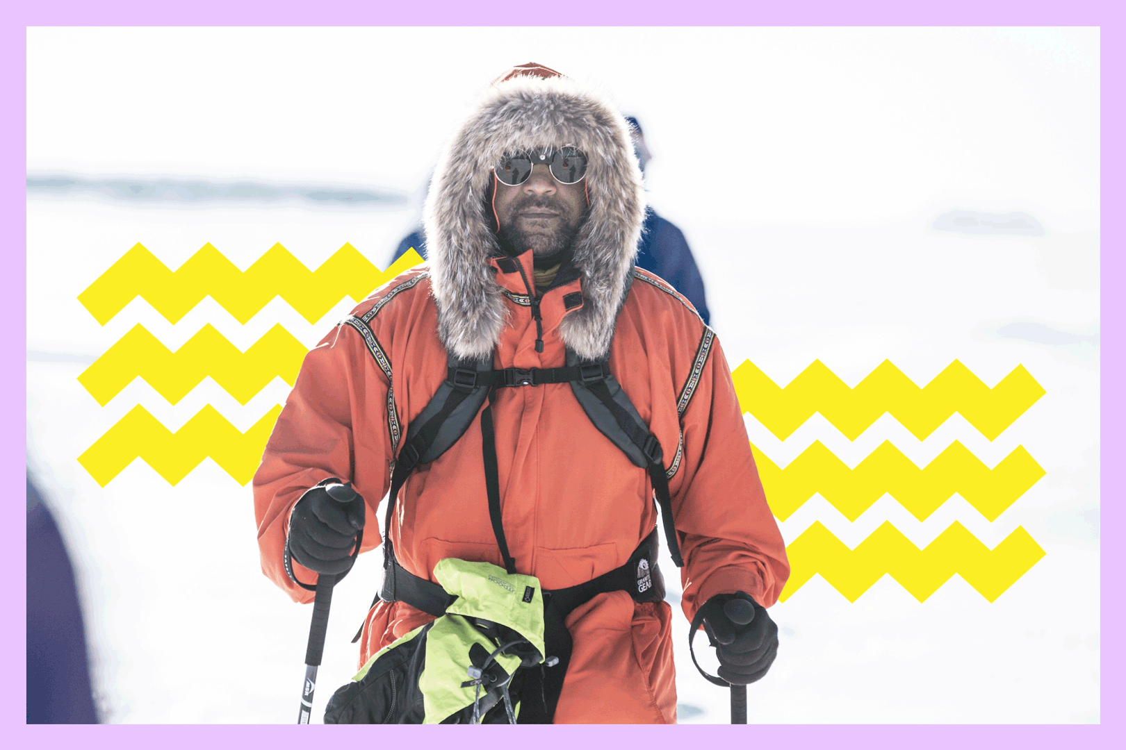 James Edward Mills walks wearing a hooded fur parka and carrying trekking poles.