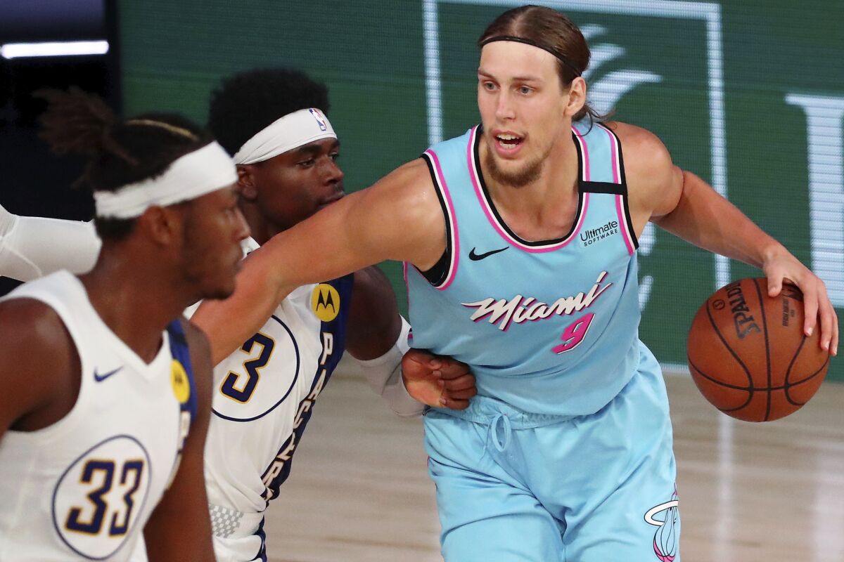 Miami Heat forward Kelly Olynyk (9) dribbles against Indiana Pacers guard Aaron Holiday (3) during the second half of an NBA basketball game Monday, Aug. 10, 2020, in Lake Buena Vista, Fla. (Kim Klement/Pool Photo via AP)