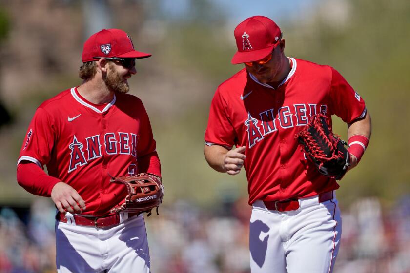 Los Angeles Angels' Mike Trout, left and Taylor Ward laugh during the third inning of a spring training baseball game against the Arizona Diamondbacks, Saturday, March 2, 2024, in Tempe, Ariz. (AP Photo/Matt York)