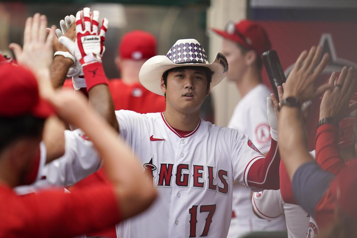Angels designated hitter Shohei Ohtani celebrates in the dugout after hitting a home run.