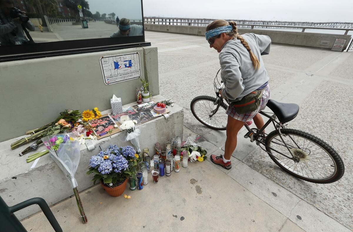 Alicia Carman of Ventura looks at a memorial outside of Aloha Steakhouse on the promenade in Ventura where Anthony Mele Jr., 35, was stabbed to death.