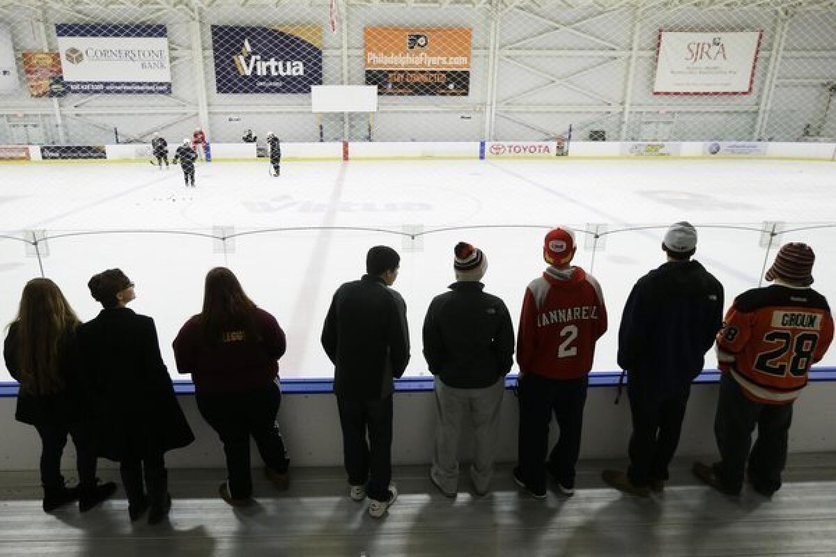 Hockey fans watch players practice at the Philadelphia Flyers' training facility Monday, a day after a tentative deal was struck to end the labor dispute that had threatened to wipe out the entire season.