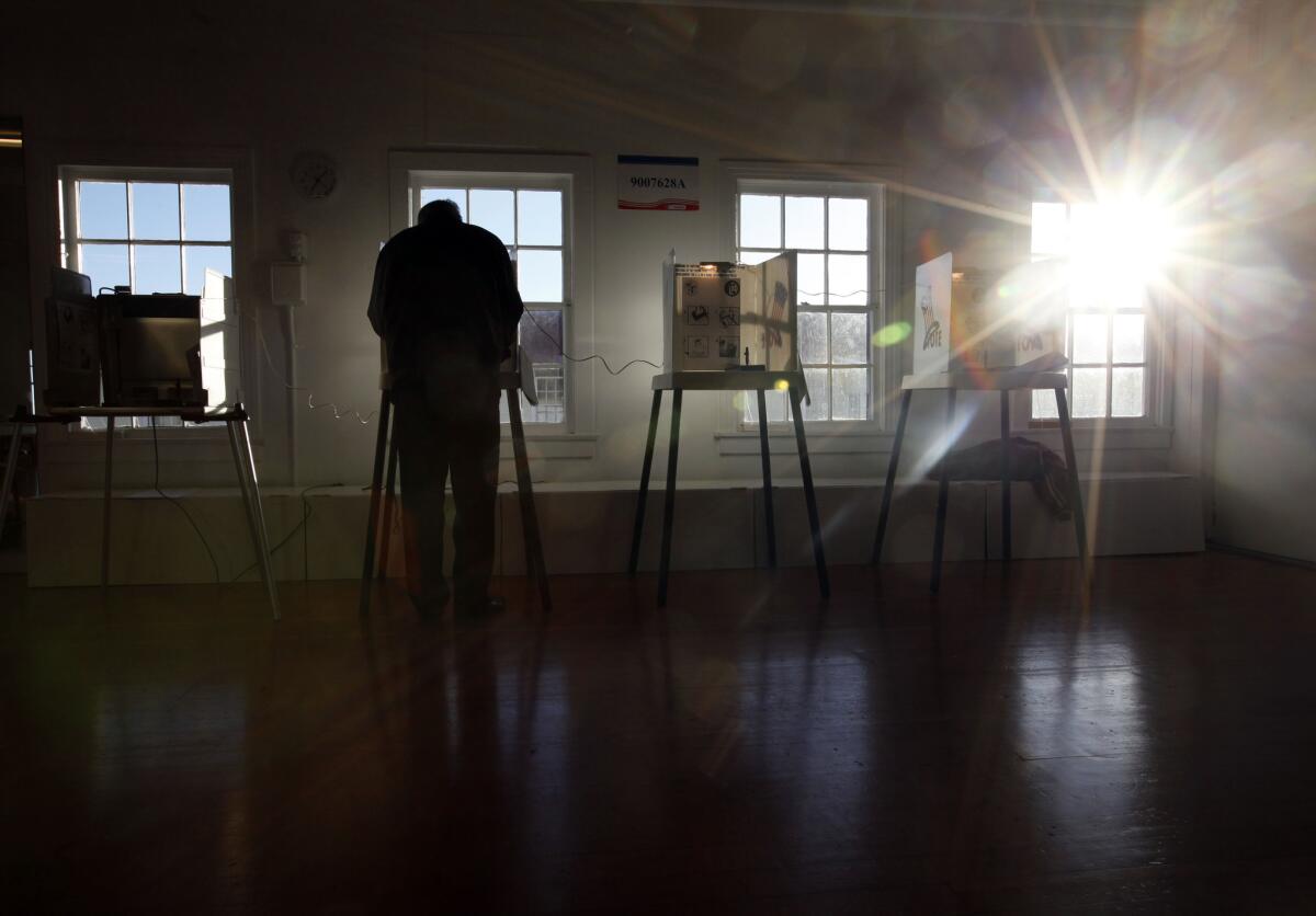 Voter Jim McShane is the only one at the Angel's Gate cultural center voting station before 7:15 a.m. Tuesday.