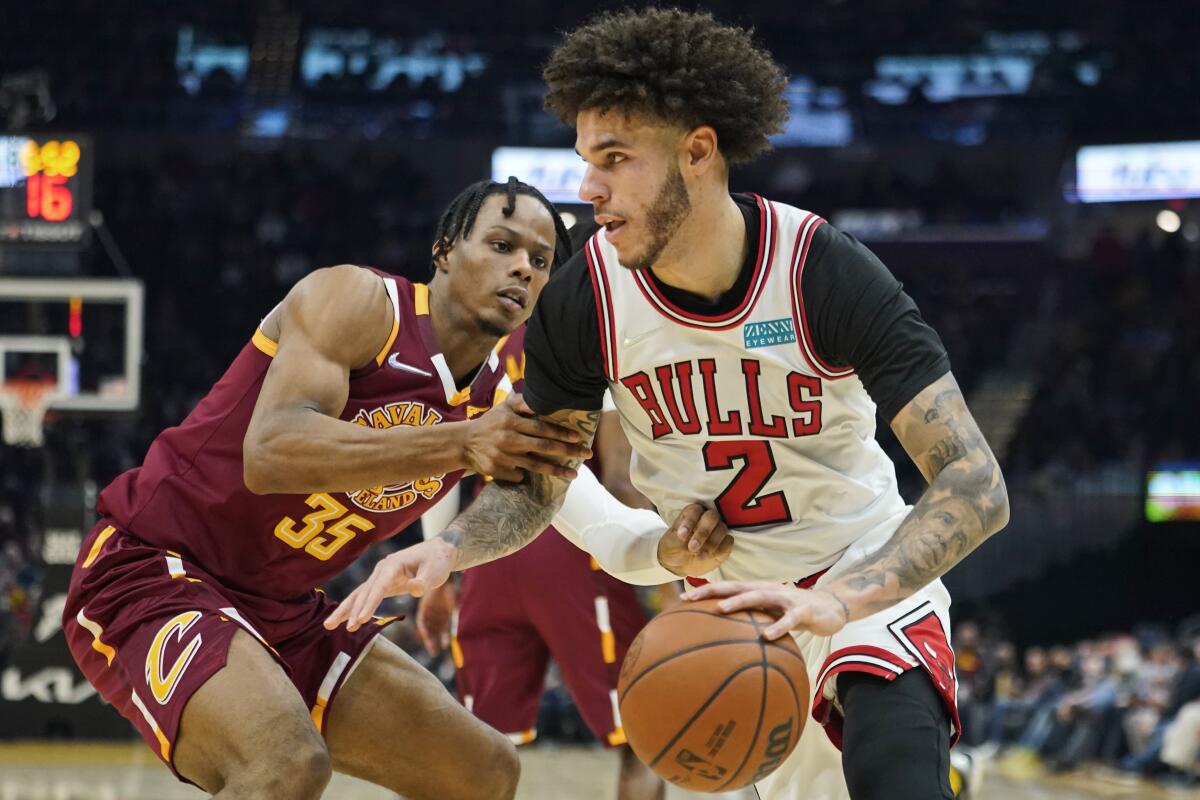 Bulls guard Lonzo Ball, right, drives against Cleveland's Isaac Okoro during a game in 2021.