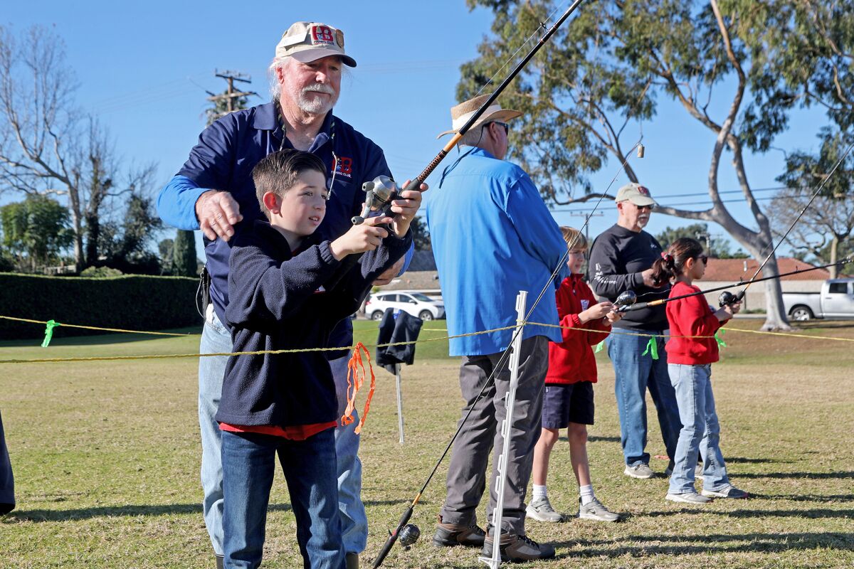 Huntington Beach Fishing and Recreation Club member Pat Carillo teaches Jack Brodsky, 11,how to cast a line at Carr Park.