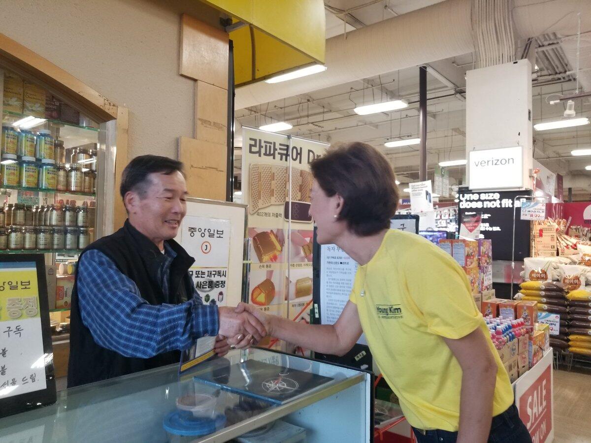 Bong Soo Lee, left, shakes hands with Republican Young Kim, who's running to replace Rep. Ed Royce in the 39th District.