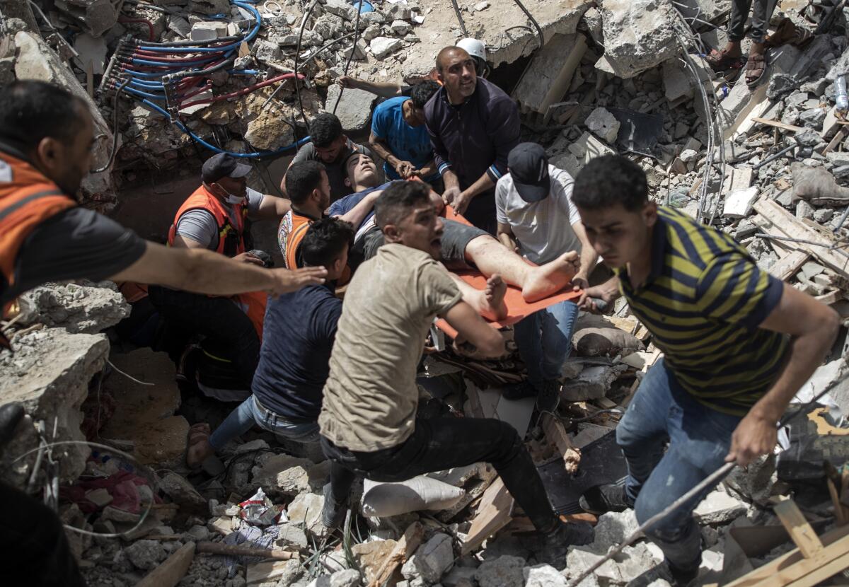 Palestinos sacan a un sobreviviente entre los escombros de un edificio residencial destruido 