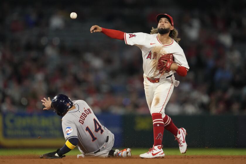 Los Angeles Angels shortstop Jack López (10) throws to first to complete a double play.