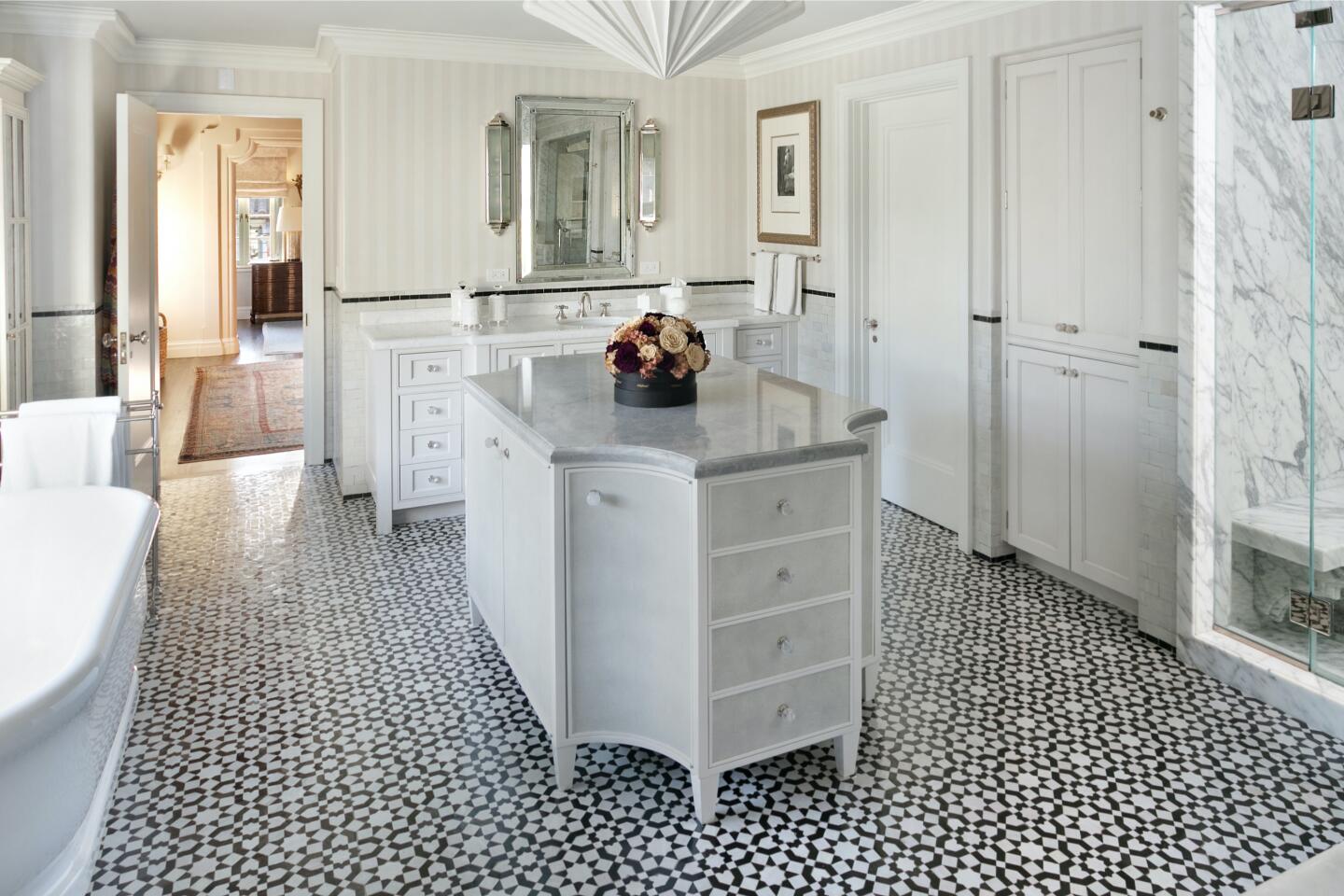 The bathroom has a shower, tub and island on a patterned floor.