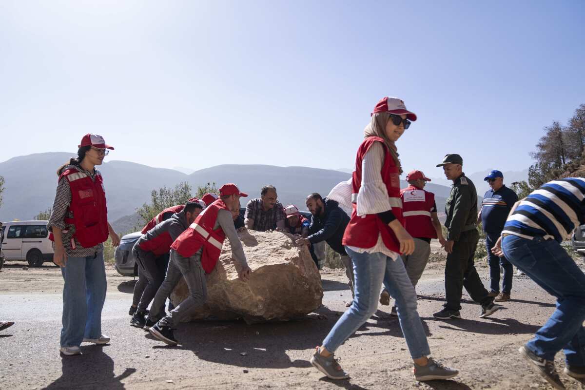 Moroccan Red Crescent workers helping to remove large stones after an earthquake