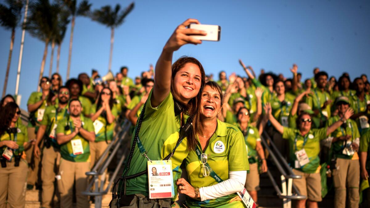 Olympic staff and volunteers take a group selfie as the sun sets in Rio de Janeiro on Thursday.