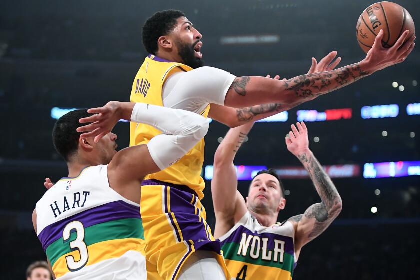 LOS ANGELES, CALIFORNIA FEBUARY 25, 2020-Lakers Anthony Davis drives to the basket between Pelicans Josh Hart (3) and J.J. Redick in the 1st qusrter at the Staples Center Tuesday. (Wally Skalij/Los Angeles Times)