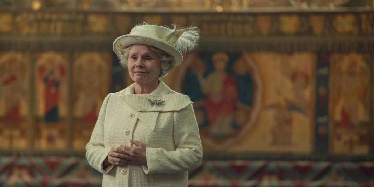 Imelda Staunton as Queen Elizabeth II standing in a cathedral in a white dress and hat.