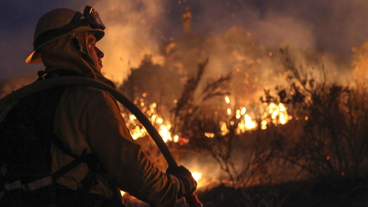 A firefighter works to contain the Border fire in eastern San Diego County on June 21.