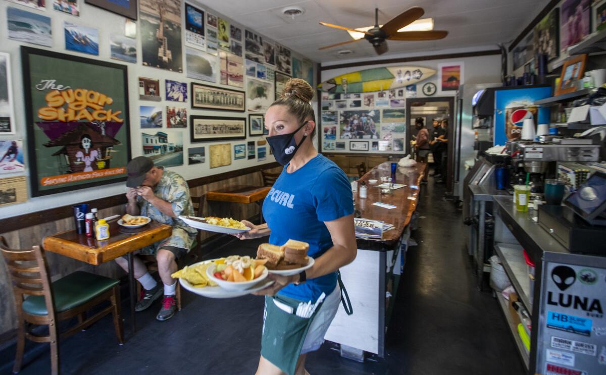 Waitress Jessica Turner brings meals to customers at Michele's Sugar Shack Cafe on Sept. 21, 2020.